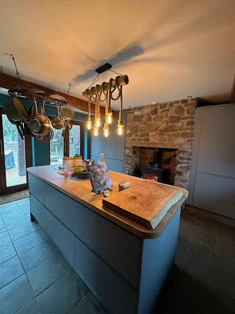 Kitchen featuring stone fireplace and custom timber countertop