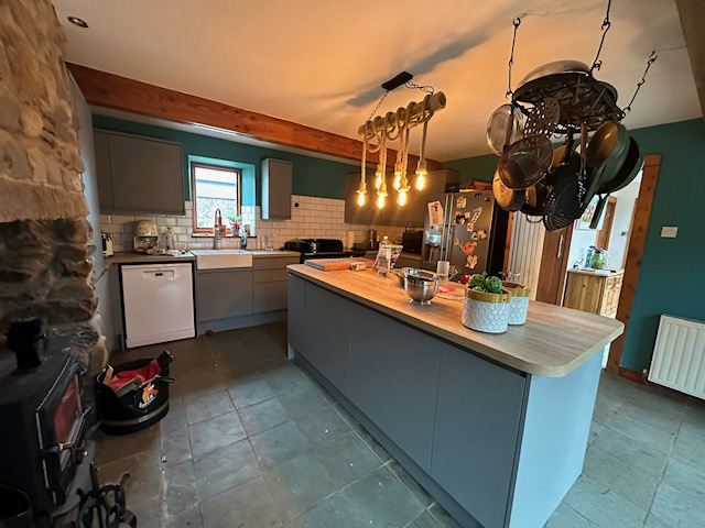 Rustic kitchen with blue cabinets and stone wall